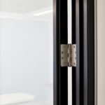 Hinge used to fix a glass office door within office partitioning